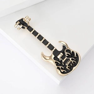 Detail of creative electric guitar brooch featuring black enamel and golden flame patterns