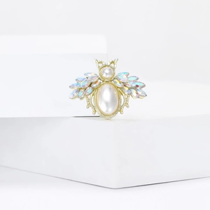 Creative bee brooch with iridescent rhinestones and pearls on a golden base