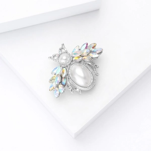 Detailed macro shot of a pearl and AB rhinestone bee brooch with silver alloy base