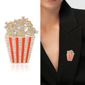 Spilla creativa a popcorn con strass brillanti e smalto rosso sul risvolto della giacca