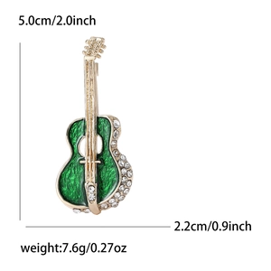 Elegant gold guitar brooch with emerald enamel and rhinestones on white background