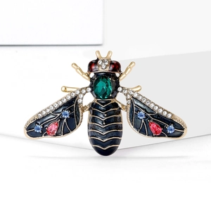 Elegant gold bee brooch with black enamel and multi-colored crystals on white background