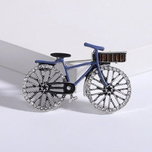 Detailed shot of a vintage bicycle brooch featuring blue enamel and sparkling rhinestones