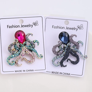 Detailed comparison of pink and dark blue octopus brooches with vibrant rhinestone crystals