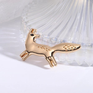 Macro shot of a golden fox brooch with running pose and textured alloy details