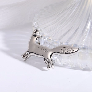 Macro shot of a silver fox brooch pin showing detailed metal texture and engraved patterns