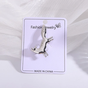 Silver jumping animal brooch with textured finish on a purple display card packaging