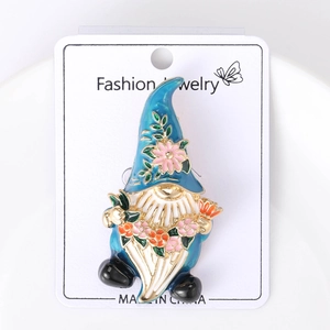 Détail de la broche gnome en émail bleu avec fleur rose sur carte d'affichage