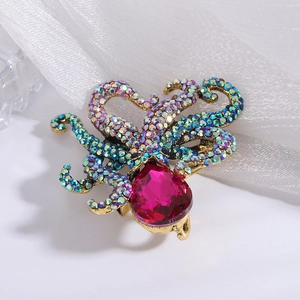 Macro detail of octopus brooch with pink pear-shaped gemstone and iridescent crystals