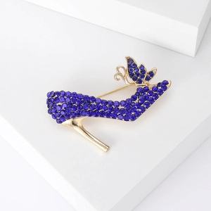 Detaillierte Brosche in High-Heel-Form mit blauen Strasssteinen auf weißem Sockel