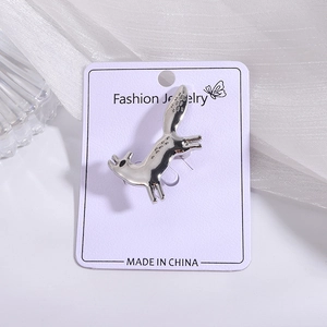 Detailed view of a silver fox brooch pin with high-polish finish on a purple display card