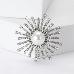 Détail d'une broche tournesol argentée avec perle centrale et strass scintillants