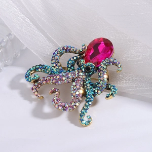 Detail of octopus brooch featuring a pink drop stone and iridescent blue-green crystals
