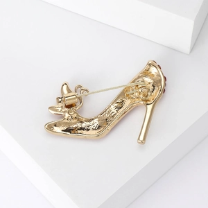 Detailansicht der High-Heel-Brosche mit Goldbeschichtung und roten Strass-Akzenten