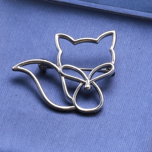 Broche renard argentée minimaliste au design ajouré sur une boîte à bijoux bleue