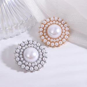 Elegant pearl brooch with gold and silver base on white silk and glass background