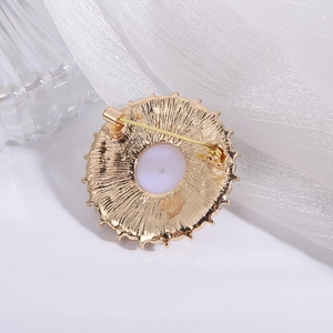 Detailed macro view of the gold-plated metal back with radial texture on a pearl brooch