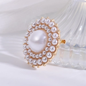 Macro shot of an elegant pearl brooch with a golden base on a white surface
