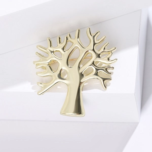 Gros plan d'une broche dorée en forme d'arbre avec des courbes métalliques lisses et polies