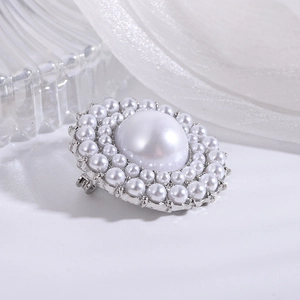 Detailed close-up of a circular pearl brooch with multi-layer pearls in silver claw setting