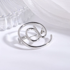 Detailed macro view of silver @ symbol brooch with a polished finish and pin closure