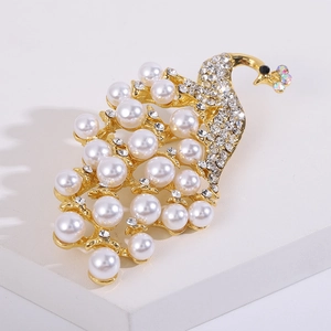 Makro-Detail der eleganten goldenen Pfauenbrosche mit weißen Perlen und Kristallen