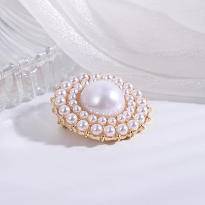 Detailed macro view of an elegant round pearl brooch with double-layered small pearls on gold base