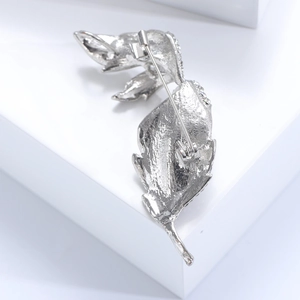 Detailed back view of a silver leaf brooch with safety pin clasp and pavé rhinestones