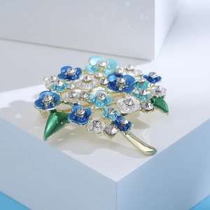 Detailed macro view of enamel hydrangea brooch with blue petals and sparkling rhinestones