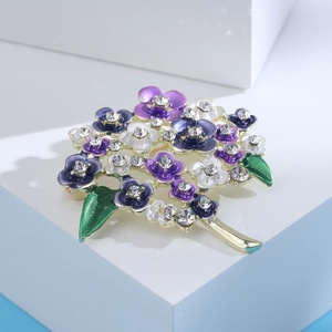 Macro shot of hydrangea brooch with purple enamel petals and sparkling crystal center