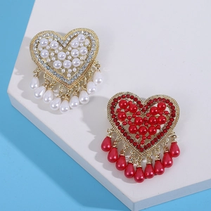 Detail of heart shape brooch with white pearls and rhinestones on gold alloy base