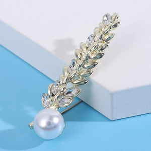 Close-up of elegant silver wheat ear brooch with sparkling crystals and a large white pearl