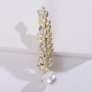 Detailed view of a gold wheat brooch featuring clear marquise crystals and a white pearl