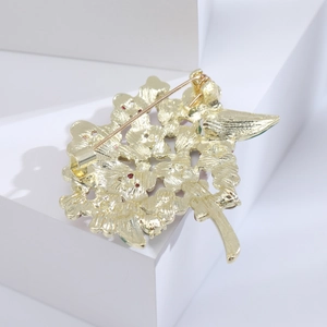 Back view of gold floral brooch with matte metal texture and secure pin-back clasp