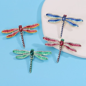 Detailed macro view of enamel dragonfly brooches with sparkling crystals in four vibrant colors