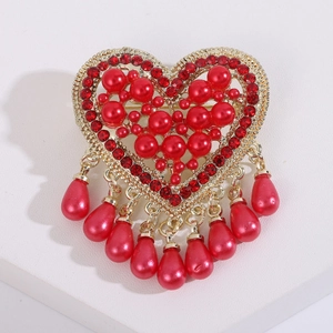Detail of red heart brooch with crystal rhinestones and teardrop pearl pendants