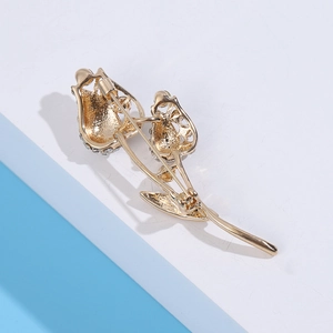 Détail d'une broche tulipe dorée avec strass et fermoir à épingle de sécurité