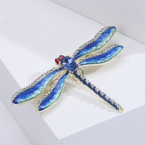 Close-up of enamel dragonfly brooch with blue crystal wings and sparkling rhinestones