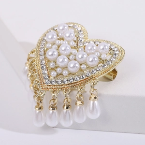 Elegant heart-shaped brooch with pearls and rhinestones on a gold metal frame