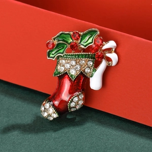 Weihnachtssocken-Brosche mit roter Emaille und Strass auf einer festlichen Geschenkbox