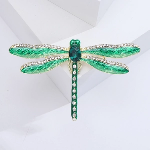 Detailed close-up of dragonfly brooch with green enamel wings and sparkling rhinestones
