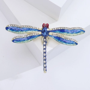 Detail view of colorful dragonfly brooch with blue enamel wings and inlaid rhinestones