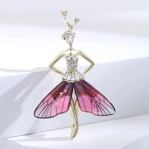 Macro detail of ballerina brooch featuring golden alloy frame and red translucent wings
