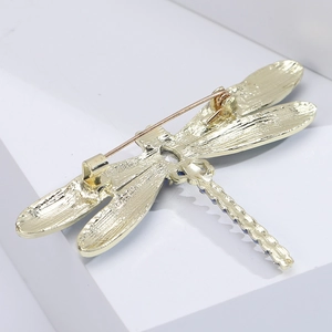 Detailed back view of golden dragonfly brooch showing pin closure and blue rhinestones