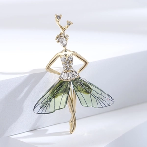 Detail of elegant gold elf brooch with green resin wings and sparkling crystals