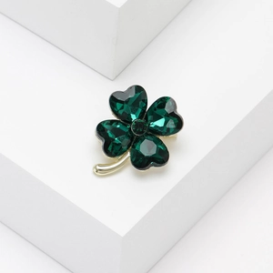 Detail of crystal four-leaf clover brooch with deep green heart gems and gold finish