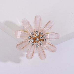 Detailed view of elegant pink flower brooch with sparkling petals and white rhinestones