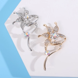Close-up of elegant flower brooches in gold and silver with sparkling rhinestones