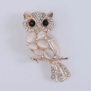 Detailed view of owl brooch with cat eye stone, gold plating and sparkling crystals