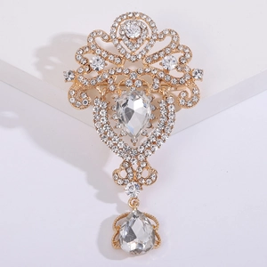 Vista macro de broche vintage dorado con cristales de gota transparentes y diamantes